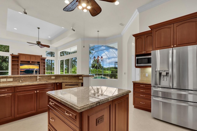 8732 Bally Bunion Rd, Port Saint Lucie, FL 34986 - kitchen with stainless steel appliances, ceiling fan, decorative backsplash, light stone countertops, and ornamental molding