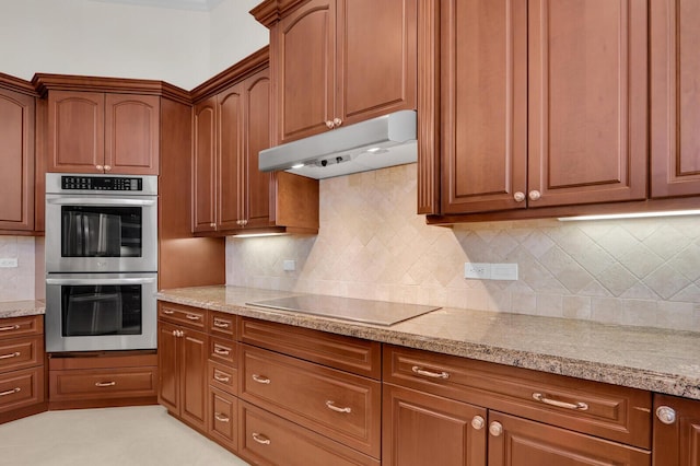 8732 Bally Bunion Rd, Port Saint Lucie, FL 34986 - kitchen with double oven, electric cooktop, under cabinet range hood, and light stone counters