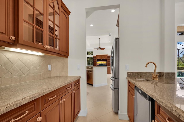 8732 Bally Bunion Rd, Port Saint Lucie, FL 34986 - kitchen featuring appliances with stainless steel finishes, light stone countertops, tasteful backsplash, glass insert cabinets, and recessed lighting