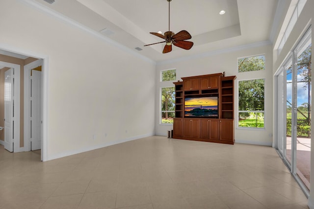 8732 Bally Bunion Rd, Port Saint Lucie, FL 34986 - unfurnished living room with plenty of natural light, ceiling fan, a tray ceiling, and ornamental molding