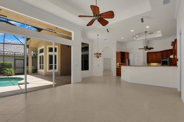 8732 Bally Bunion Rd, Port Saint Lucie, FL 34986 - unfurnished living room with a high ceiling, a tray ceiling, ceiling fan, light tile patterned floors, and recessed lighting
