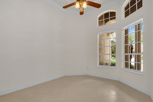 8732 Bally Bunion Rd, Port Saint Lucie, FL 34986 - empty room with healthy amount of natural light, light tile patterned flooring, a ceiling fan, and a high ceiling