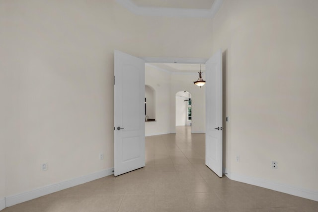 8732 Bally Bunion Rd, Port Saint Lucie, FL 34986 - spare room featuring arched walkways, light tile patterned floors, a tray ceiling, and ornamental molding