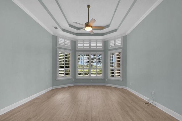 8732 Bally Bunion Rd, Port Saint Lucie, FL 34986 - empty room featuring a ceiling fan, a tray ceiling, wood finished floors, and crown molding