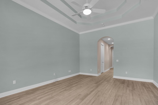 8732 Bally Bunion Rd, Port Saint Lucie, FL 34986 - spare room with arched walkways, a raised ceiling, a ceiling fan, light wood-style floors, and ornamental molding