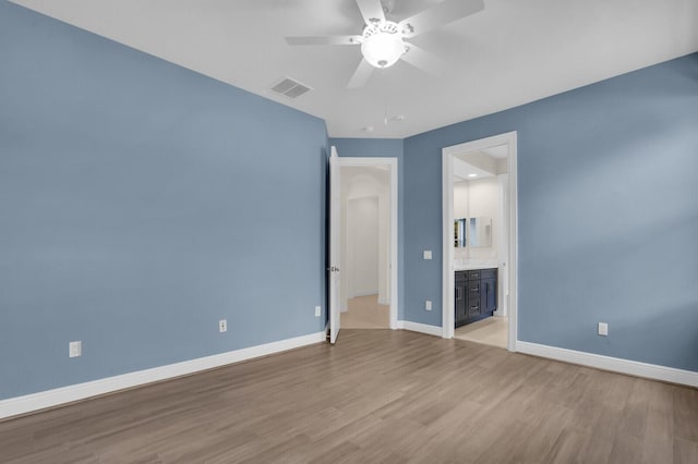 8732 Bally Bunion Rd, Port Saint Lucie, FL 34986 - unfurnished bedroom with wood finished floors, ceiling fan, and ensuite bathroom