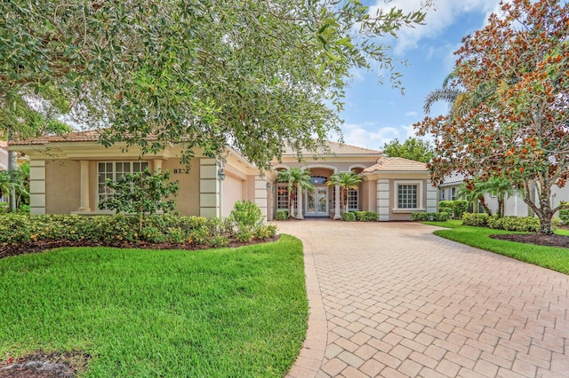 8732 Bally Bunion Rd, Port Saint Lucie, FL 34986 - mediterranean / spanish house with decorative driveway, an attached garage, stucco siding, and a front yard