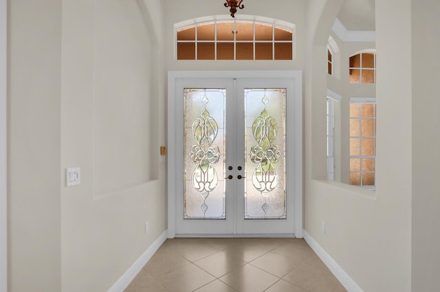 8732 Bally Bunion Rd, Port Saint Lucie, FL 34986 - foyer entrance with french doors, light tile patterned flooring, a high ceiling, and arched walkways