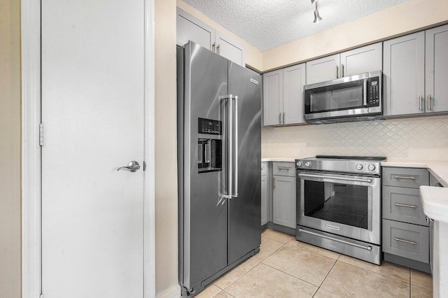 1000 Crystal Way Unit J, Delray Beach, FL 33444 - kitchen featuring appliances with stainless steel finishes, gray cabinetry, a textured ceiling, light countertops, and tasteful backsplash