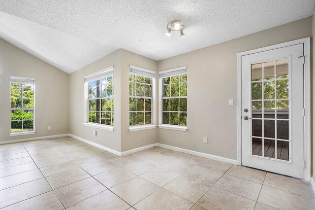 1000 Crystal Way Unit J, Delray Beach, FL 33444 - unfurnished room featuring light tile patterned floors, healthy amount of natural light, a textured ceiling, and lofted ceiling
