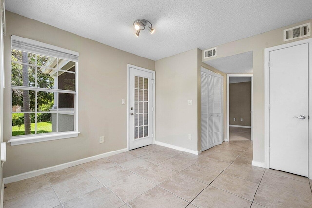 1000 Crystal Way Unit J, Delray Beach, FL 33444 - empty room featuring light tile patterned floors and a textured ceiling