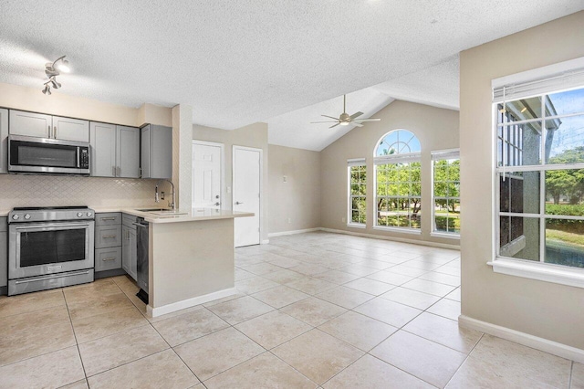 1000 Crystal Way Unit J, Delray Beach, FL 33444 - kitchen featuring stainless steel appliances, gray cabinetry, a peninsula, light tile patterned floors, and open floor plan