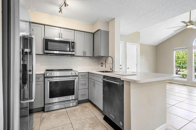 1000 Crystal Way Unit J, Delray Beach, FL 33444 - kitchen featuring stainless steel appliances, gray cabinetry, light tile patterned floors, a peninsula, and a textured ceiling