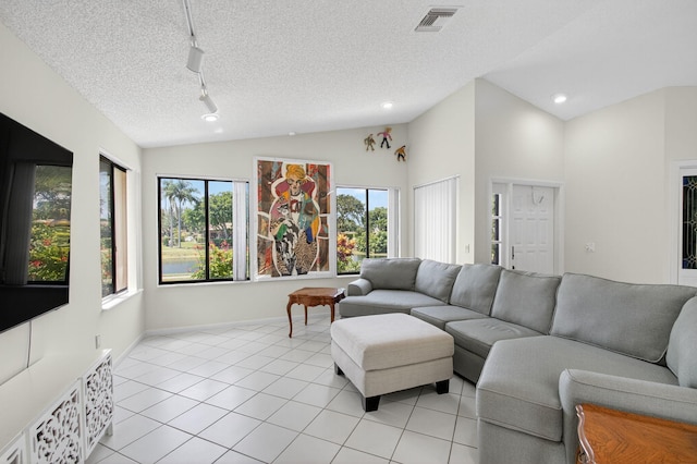 3010 NW 12th St Unit D, Delray Beach, FL 33445 - living room with rail lighting, light tile patterned flooring, vaulted ceiling, a textured ceiling, and recessed lighting