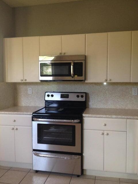 3306 Shoma Dr Unit 305, Royal Palm Beach, FL 33414 - kitchen with stainless steel appliances, light countertops, tasteful backsplash, and light tile patterned flooring