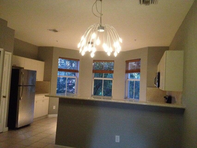 3306 Shoma Dr Unit 305, Royal Palm Beach, FL 33414 - kitchen with freestanding refrigerator, a chandelier, white cabinets, and a peninsula