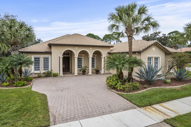 801 SW Classico Ct, Port Saint Lucie, FL 34986 - mediterranean / spanish home featuring decorative driveway, a tile roof, stucco siding, and a front lawn
