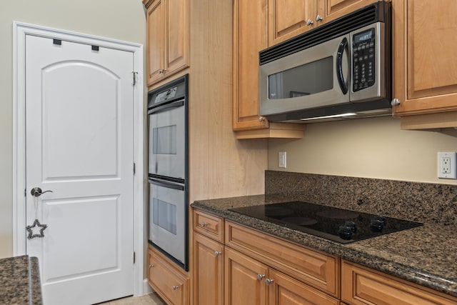 801 SW Classico Ct, Port Saint Lucie, FL 34986 - kitchen with stainless steel appliances, dark stone countertops, and brown cabinetry