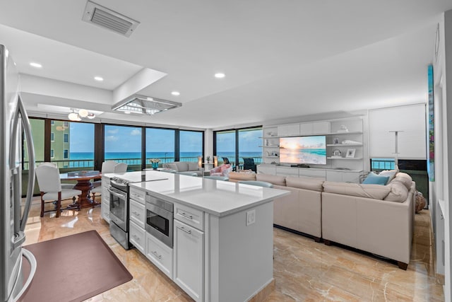 5280 N Ocean Dr Unit 3B, Singer Island, FL 33404 - kitchen with appliances with stainless steel finishes, open floor plan, light marble finish floors, light countertops, and a center island