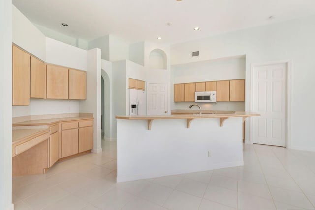 6025 Fountain Palm Dr, Jupiter, FL 33458 - kitchen with white appliances, a high ceiling, a kitchen breakfast bar, light countertops, and recessed lighting