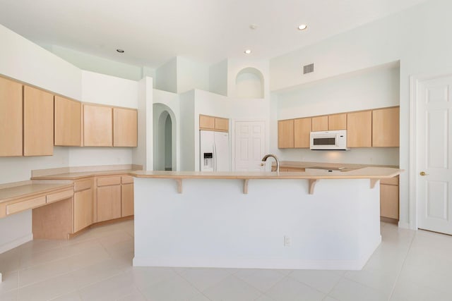 6025 Fountain Palm Dr, Jupiter, FL 33458 - kitchen with white appliances, light brown cabinets, a kitchen breakfast bar, light countertops, and a spacious island