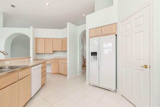 6025 Fountain Palm Dr, Jupiter, FL 33458 - kitchen with white appliances, light brown cabinets, arched walkways, light tile patterned flooring, and recessed lighting