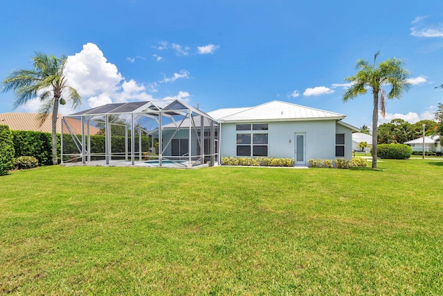 6025 Fountain Palm Dr, Jupiter, FL 33458 - rear view of property featuring a yard, stucco siding, glass enclosure, a metal roof, and an outdoor pool