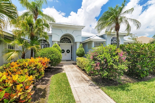6025 Fountain Palm Dr, Jupiter, FL 33458 - view of front of house with stucco siding and a metal roof