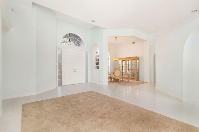 6025 Fountain Palm Dr, Jupiter, FL 33458 - carpeted foyer entrance featuring tile patterned flooring, arched walkways, recessed lighting, and a high ceiling