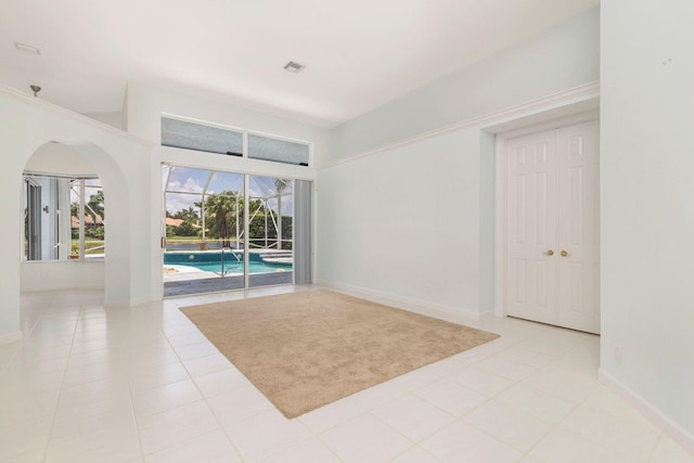 6025 Fountain Palm Dr, Jupiter, FL 33458 - tiled spare room with plenty of natural light and arched walkways