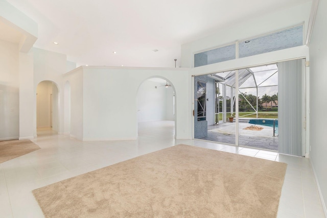 6025 Fountain Palm Dr, Jupiter, FL 33458 - tiled empty room featuring arched walkways, a sunroom, a high ceiling, and recessed lighting