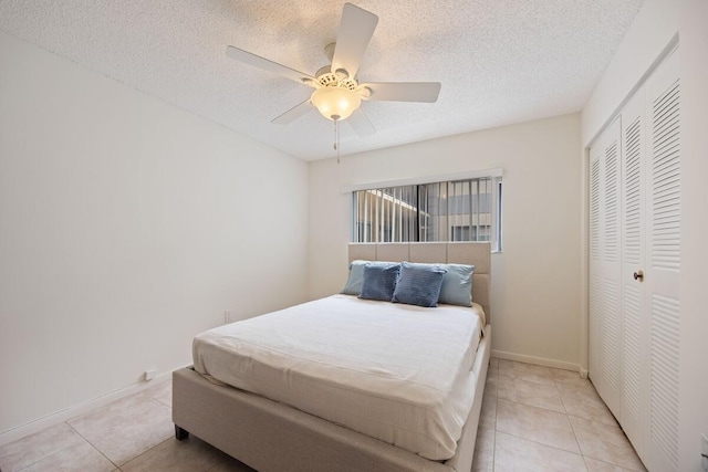 15378 Lakes Of Delray Blvd Unit 15, Delray Beach, FL 33484 - bedroom with light tile patterned floors, a closet, a textured ceiling, and ceiling fan