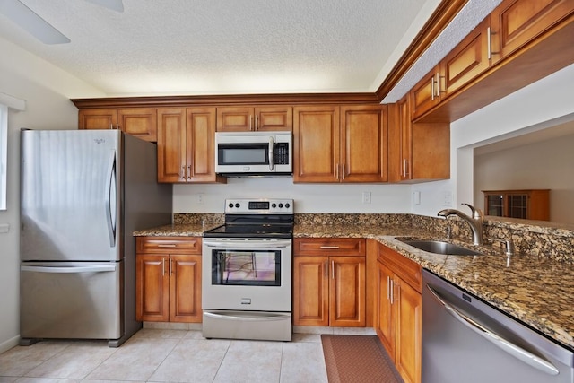 15378 Lakes Of Delray Blvd Unit 15, Delray Beach, FL 33484 - kitchen with appliances with stainless steel finishes, brown cabinetry, and a textured ceiling