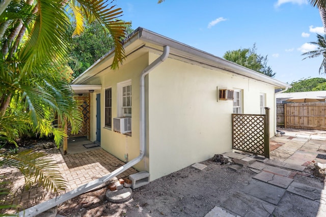 4621 N Ocean Blvd, Boynton Beach, FL 33435 - view of side of home featuring stucco siding, a patio area, and cooling unit