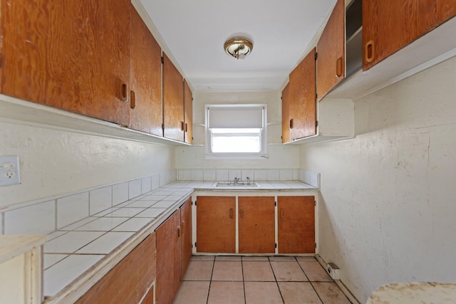 4621 N Ocean Blvd, Boynton Beach, FL 33435 - kitchen with tile counters, brown cabinets, and light tile patterned floors