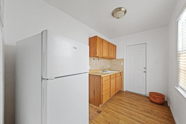4621 N Ocean Blvd, Boynton Beach, FL 33435 - kitchen featuring freestanding refrigerator, light wood-type flooring, light countertops, backsplash, and healthy amount of natural light