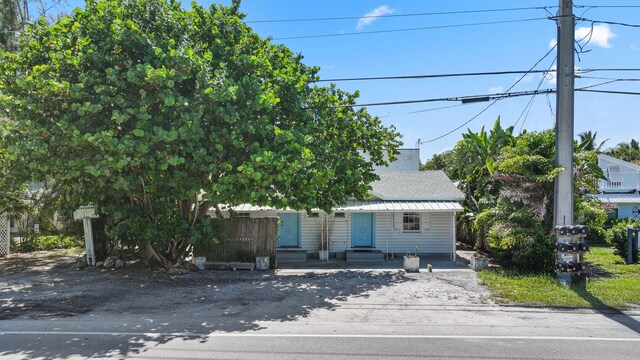 4621 N Ocean Blvd, Boynton Beach, FL 33435 - view of property hidden behind natural elements with entry steps and a shingled roof