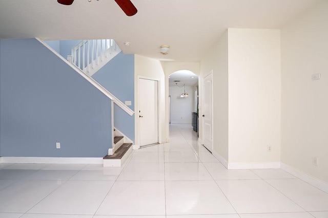 2113 SE Fern Park Dr, Port Saint Lucie, FL 34952 - empty room with arched walkways, a ceiling fan, stairway, and light tile patterned floors