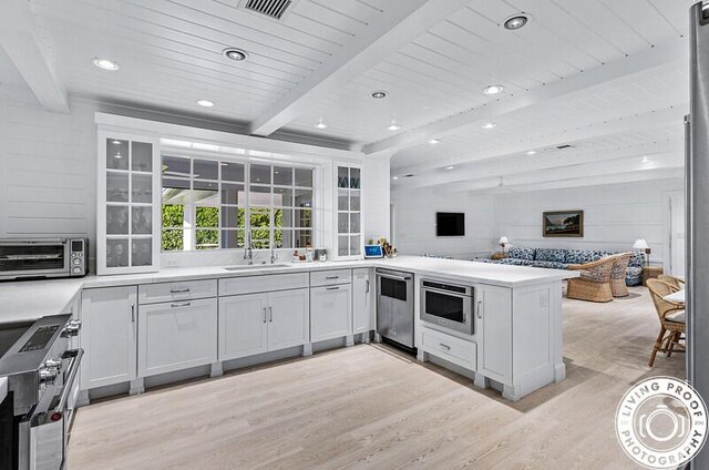 4941 S Lake Dr, Boynton Beach, FL 33436 - kitchen with appliances with stainless steel finishes, light wood-style flooring, a peninsula, open floor plan, and light countertops