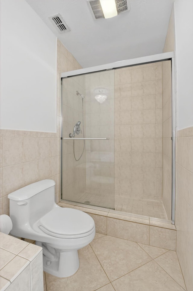 1111 Lemon Tree Ter Unit 204, Delray Beach, FL 33445 - bathroom with a shower stall, tile walls, tile patterned flooring, and wainscoting
