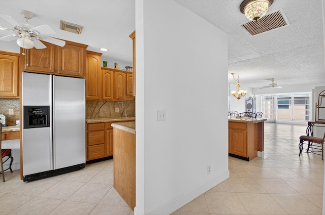1111 Lemon Tree Ter Unit 204, Delray Beach, FL 33445 - kitchen with fridge with ice dispenser, ceiling fan, light tile patterned floors, backsplash, and a textured ceiling