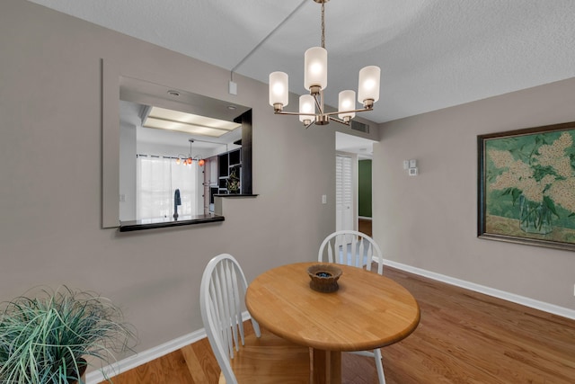 14623 Bonaire Blvd Unit 203, Delray Beach, FL 33446 - dining room featuring a chandelier and wood finished floors