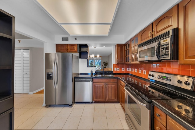 14623 Bonaire Blvd Unit 203, Delray Beach, FL 33446 - kitchen with appliances with stainless steel finishes, brown cabinets, glass insert cabinets, and tasteful backsplash