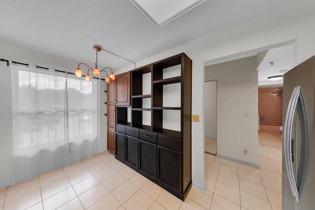 14623 Bonaire Blvd Unit 203, Delray Beach, FL 33446 - unfurnished dining area featuring light tile patterned flooring, a textured ceiling, and a chandelier