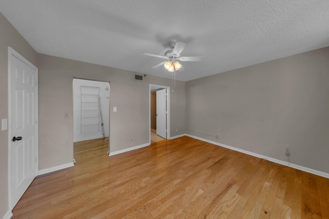 14623 Bonaire Blvd Unit 203, Delray Beach, FL 33446 - unfurnished bedroom featuring a textured ceiling, light wood-style floors, and a ceiling fan