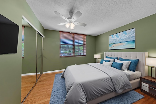 14623 Bonaire Blvd Unit 203, Delray Beach, FL 33446 - bedroom featuring a closet, wood finished floors, a textured ceiling, and a ceiling fan