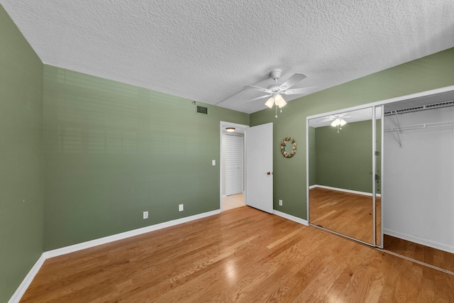 14623 Bonaire Blvd Unit 203, Delray Beach, FL 33446 - unfurnished bedroom with wood finished floors, a closet, a ceiling fan, and a textured ceiling