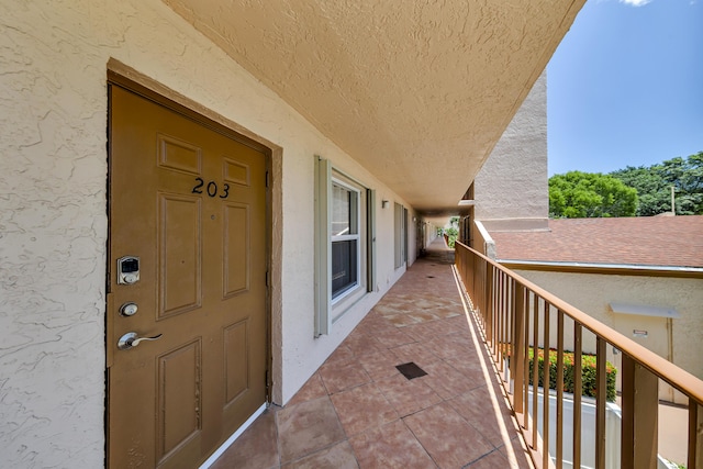 14623 Bonaire Blvd Unit 203, Delray Beach, FL 33446 - view of exterior entry with stucco siding and a balcony