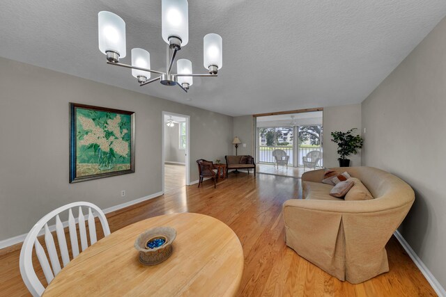 14623 Bonaire Blvd Unit 203, Delray Beach, FL 33446 - dining space featuring a textured ceiling, a chandelier, and light wood finished floors