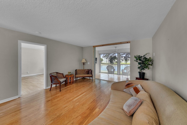 14623 Bonaire Blvd Unit 203, Delray Beach, FL 33446 - living area with light wood-style flooring and a textured ceiling